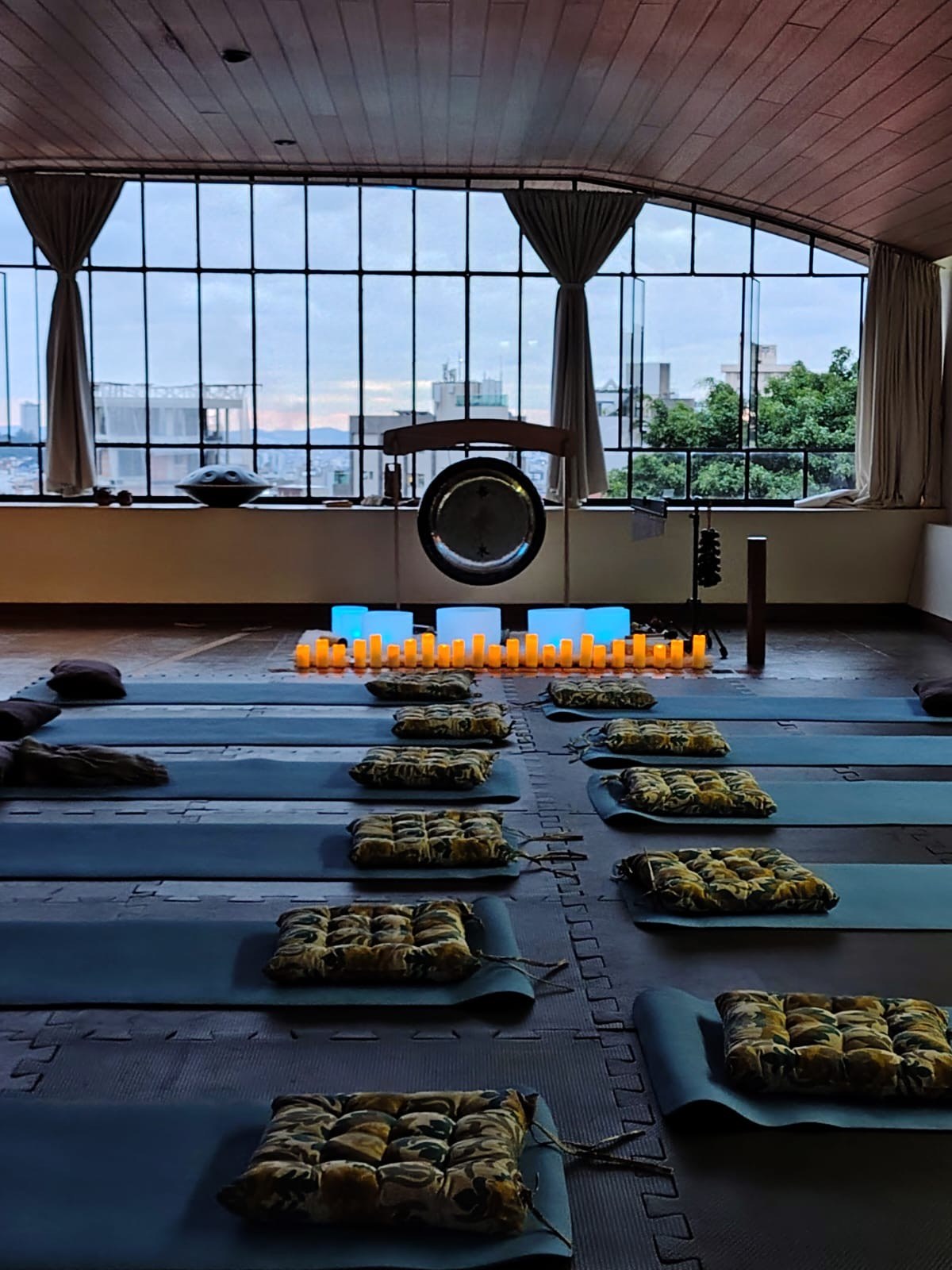 Gongo, tigelas de cristal e velas preparados para o sound healing