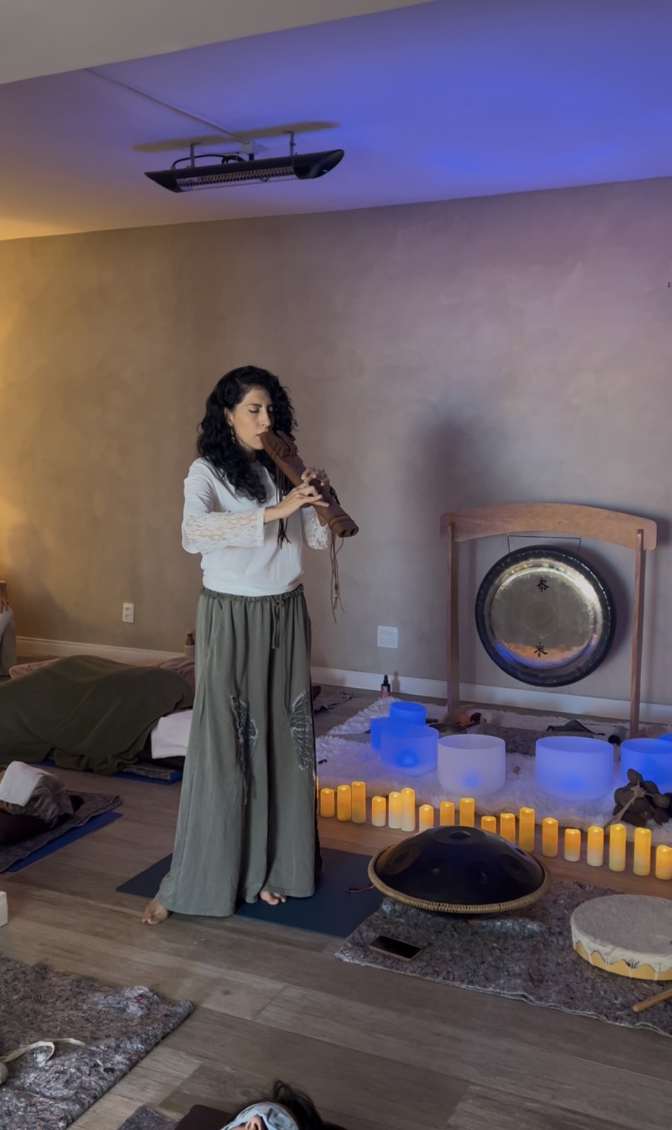 Cynthia tocando flauta ancestral durante o workshop